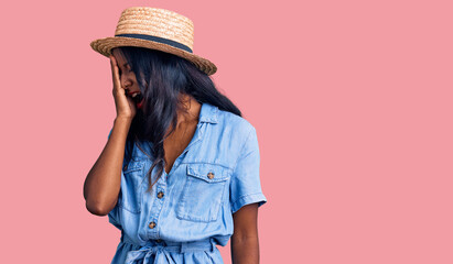 Young indian girl wearing summer hat yawning tired covering half face, eye and mouth with hand. face hurts in pain.