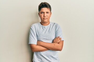 Teenager hispanic boy wearing casual grey t shirt skeptic and nervous, disapproving expression on...