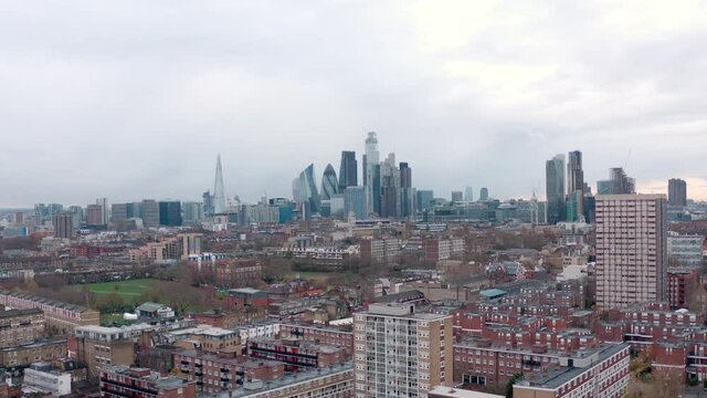 Aerial circling slider shot over residential area to central London skyscrapers