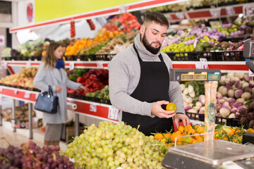 Shopping assistant puts vegetables and fruits on supermarket counter. High quality photo