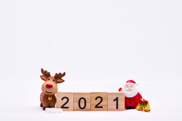 Happy New Year and Merry Christmas 2021 concept. Ceramic happy Santa Claus and reindeer doll with gold bell standing side wooden text 2021. On isolated white background.