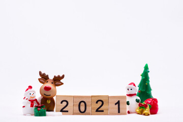 Happy New Year and Merry Christmas 2021 concept. Ceramic happy Snow man and reindeer doll with gift box and gold bell standing side wooden text 2021. On isolated white background.