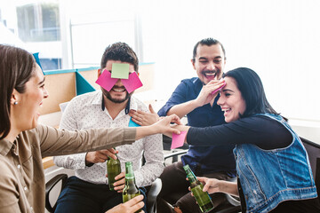 young hispanic business professionals celebrating a success with beers in creative office in Mexico city
