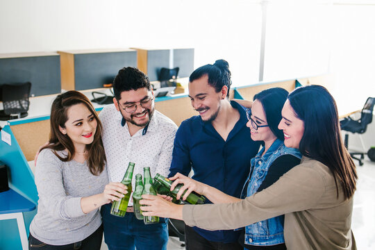 Hispanic Business People Having Fun With Beers In Creative Office Happy Hour In Mexico City