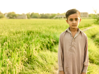 a poor staring hungry orphan boy and sad expression on his face and his face and clothes are dirty and his eyes are full of pain