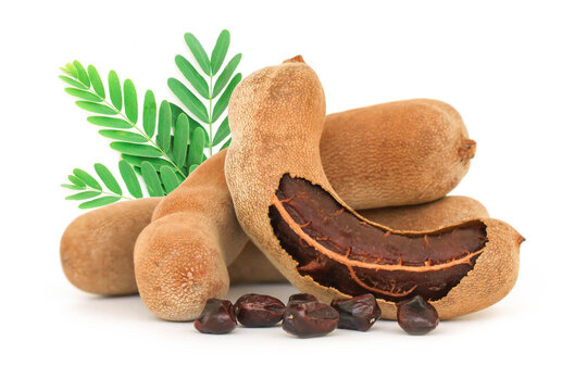 Tamarind fruits with green leaves isolated on white background.