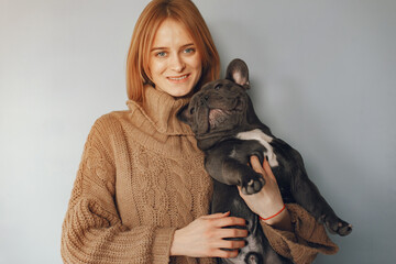 Woman with dog. Lady in a browm sweater. Girl play with bulldog.
