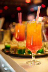 Multicolored alcoholic and non-alcoholic cocktails with ice and straws