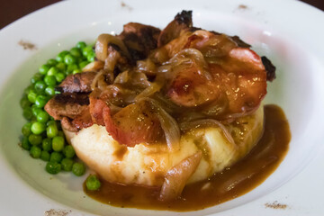 Pork liver with potato mash, peas and onion gravy