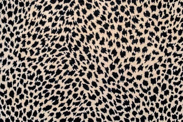 Fototapeten Textured spotted background, repeating seamless pattern of black spots on a beige or yellow background: space for text, leopard skin pattern for fabric © Leila