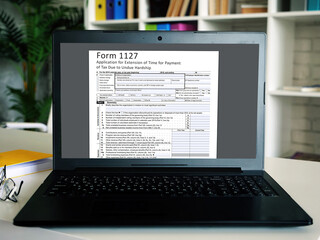 Business concept about  Form 1127 Application for Extension of Time for Payment of Tax Due to Undue Hardship  with inscription on the sheet.