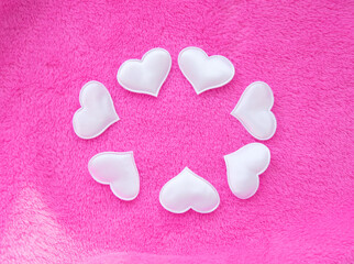 White hearts on pink delicate soft background of plush fabric.  St. Valentine's celebration, romantic concept. copy space