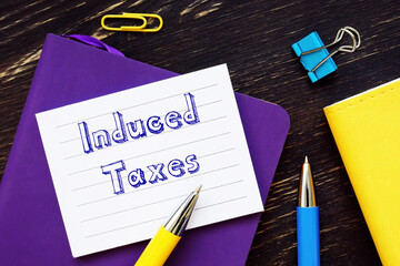 Induced Taxes phrase on the piece of paper.