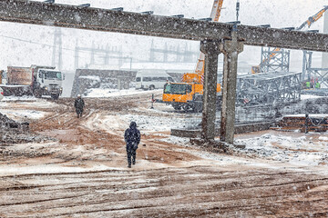 View of the construction site with snowy weather. Construction is a general term meaning the art...