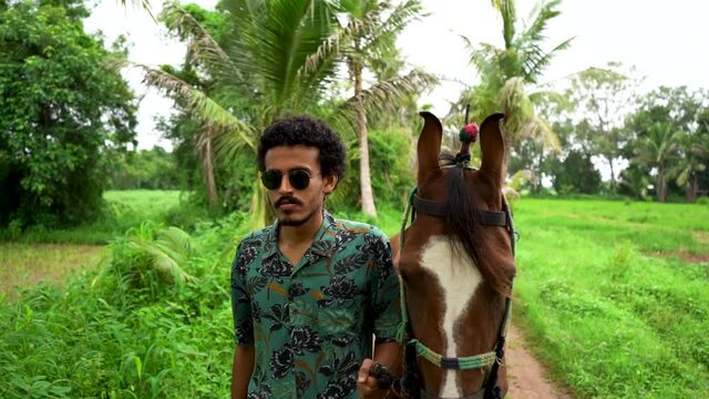 Young handsome man with brown horse.