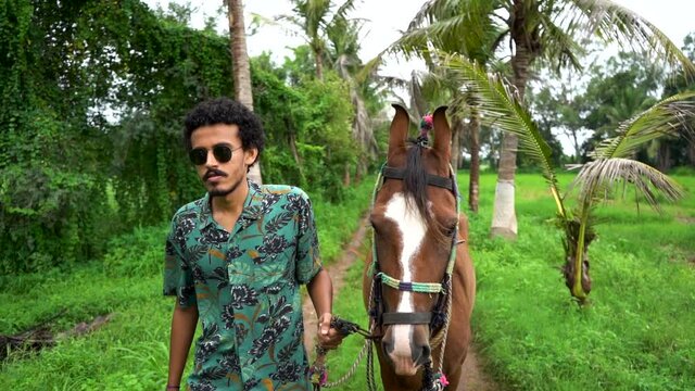 Young handsome man with brown horse.