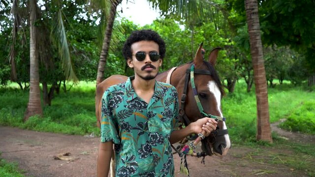 Young handsome man with brown horse.
