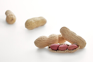 peanuts in shells isolated on white background, peeled peanuts, ripe peanut kernels close-up