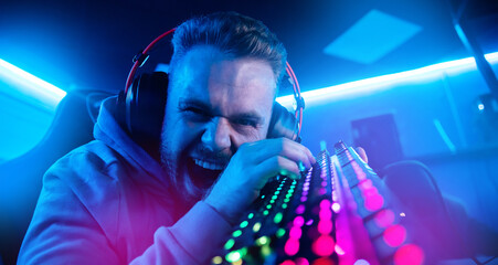Streamer Angry computer gamer man yells and breaks keyboard after being defeated in online video game © Parilov