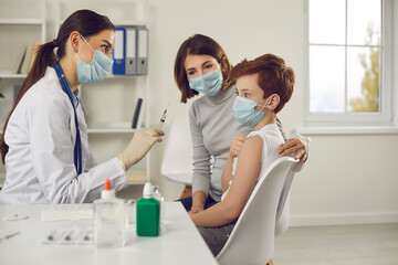 Obraz premium Scared little child makes funny face when he sees syringe needle in nurse's hand