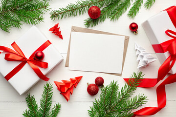 Fototapeta na wymiar Christmas greeting card mockup with gift boxes, decorations and fir tree branches on white