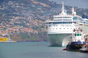 View of cruiseships cruise ship liners docked at pier in port of Funchal, Madeira with tug boat and...