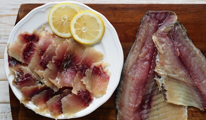 The view from the top.Fish background. Pieces of freshly salted Russian river fish, ready to eat, on the kitchen cutting Board on a white wooden table.