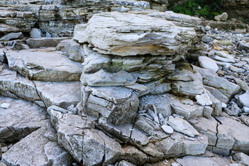 mountain textures of stones with interlayers of gypsum, colored quartz, clay, sand and other layers of various ores, with different textures, color and density, in gypsum ore quarry.