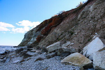 mountain textures of stones with interlayers of gypsum, colored quartz, clay, sand and other layers of various ores, with different textures, color and density, in gypsum ore quarry.