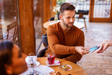 Man paying with credit card in the cafe