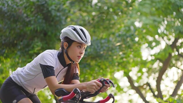 Asian young beautiful woman riding bicycle for excercise in the park.	