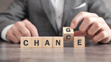 Businessman flipping text cube from Change to Chance.