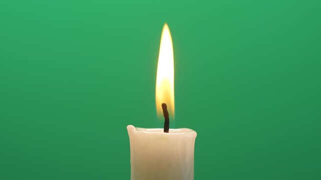 Closeup candle fire flame burning on chroma key green screen background 4K video