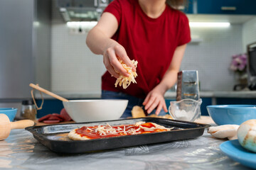 A young woman cooking a pizza. Hands close-up. Homemade cooking concept