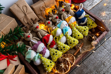A set of handmade Christmas tree toys crocheted in a wooden tray with burlap. Country style.