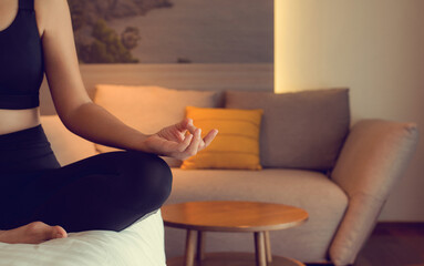 Young woman practice yoga lotus pose to meditation in bedroom after wake up in the morning. Health...