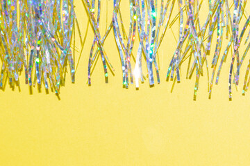 silver holographic tinsel fringe on an illuminating yellow background