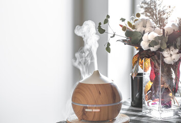 Modern oil aroma diffuser in the living room on the table copy space.