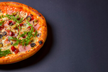Hot tasty delicious rustic homemade american pizza over black background. Traditional Italian cuisine concept.