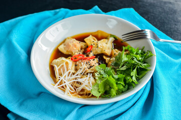 Boiled meat dumplings with fresh parsley, soy sauce and sesame seeds. Delicious meal for dinner.