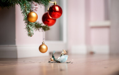 Broken Christmas ball. Fallen to the floor and shattered into pieces. Destroyed remains of glass bauble and different Christmas ornaments.