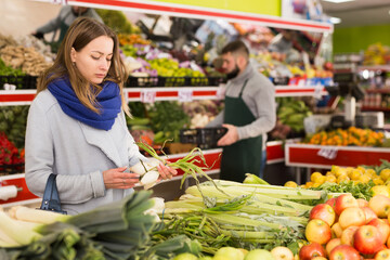 Female shopper picks onions at grocery store. High quality photo