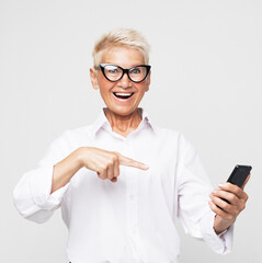 A picture of mature woman wearing eyeglasses with new smartphone.