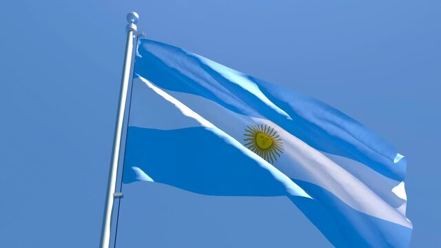 The national flag of Argentina is flying in the wind against a blue sky