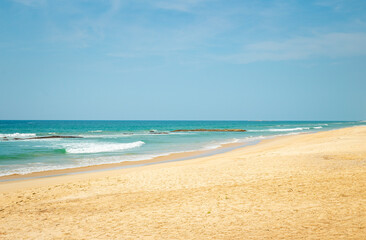 Fototapeta na wymiar Breaking sea wave with stone on a sandy beach background. Natai Beach, Phang-nga, Thailand, Asia