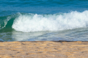 Fototapeta premium Breaking sea wave on a sandy beach background