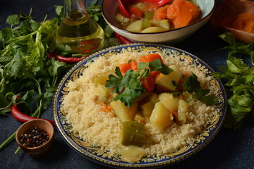 Fototapeta na wymiar Cooked couscous with green parsley in ceramic plate and vegetable stew.