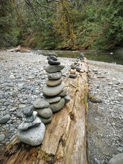 zen stone sculptures on a log in the forest