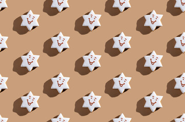 Cute gingerbread pattern. Pretty pastry decoration. Festive bakery design. Cakes illustration. Smiling white icing star figure biscuits isolated on beige pastel.