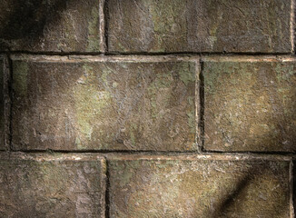 background of a fragment of a gray stone wall in sunlight through trees